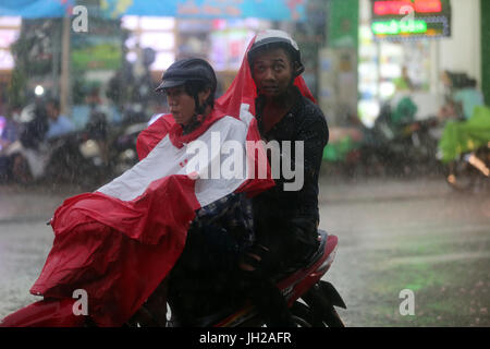 Forti piogge monsoniche. Scooter a Saigon Street. Il Vietnam. Foto Stock