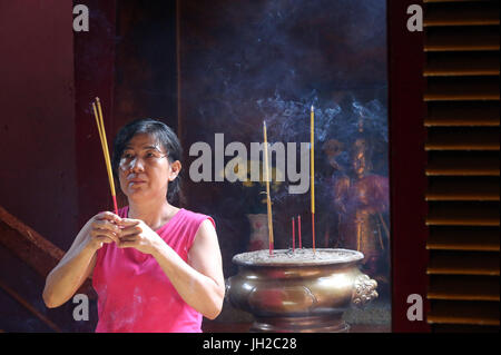 Khanh Van Nam Vien taoista pagoda. Adoratore buddista. La masterizzazione di bastoncini di incenso. Ho Chi Minh City. Il Vietnam. Foto Stock