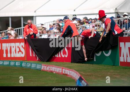 Derby, Inghilterra, 12 luglio 2017. Cricketeers, volontari e all'ICC Coppa del Mondo Donne, coprire e scoprire la pubblicità con panno nero schermi alla vista dopo ogni oltre. Credito: Colin Edwards/Alamy Live News. Foto Stock