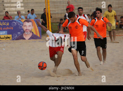 La città di Gaza, Striscia di Gaza, Territori palestinesi. 13 Luglio, 2017. Shabab palestinese Khan Younis giocatori e al-Jalaa i giocatori di competere per la sfera durante il beach soccer (calcio) partita finale, nella Striscia di Gaza City il 12 luglio 2017 Credit: Mohammed Asad/immagini APA/ZUMA filo/Alamy Live News Foto Stock