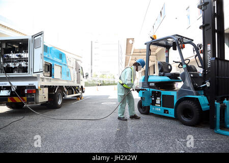 Yokohama, Giappone. 12 Luglio, 2017. Un lavoratore tasse di idrogeno per una Toyota sollevata per cella a combustibile in corrispondenza del carrello il Kirin Brewery a Yokohama, suburbana Tokyo Mercoledì, 12 luglio, 2017. Toyota Motor, Toshiba, Iwatani e i governi municipali di Yokohama e Kawasaki ha avviato una completa le operazioni di scala della tecnologia a idrogeno progetto dimostrativo utilizzando un vento generatore di potenza, Toshiba idrogeno sistema di produzione, Iwatani idrogeno del serbatoio di stoccaggio e Toyota cella a combustibile carrelli elevatori. Credito: Yoshio Tsunoda/AFLO/Alamy Live News Foto Stock