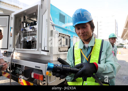 Yokohama, Giappone. 12 Luglio, 2017. Un lavoratore tasse di idrogeno per una Toyota sollevata per cella a combustibile carrello dal Iwatani's lo stoccaggio di idrogeno camion al Kirin Brewery a Yokohama, suburbana Tokyo Mercoledì, 12 luglio, 2017. Toyota Motor, Toshiba, Iwatani e i governi municipali di Yokohama e Kawasaki ha avviato una completa le operazioni di scala della tecnologia a idrogeno progetto dimostrativo utilizzando un vento generatore di potenza, Toshiba idrogeno sistema di produzione, Iwatani idrogeno del serbatoio di stoccaggio e Toyota cella a combustibile carrelli elevatori. Credito: Yoshio Tsunoda/AFLO/Alamy Live News Foto Stock