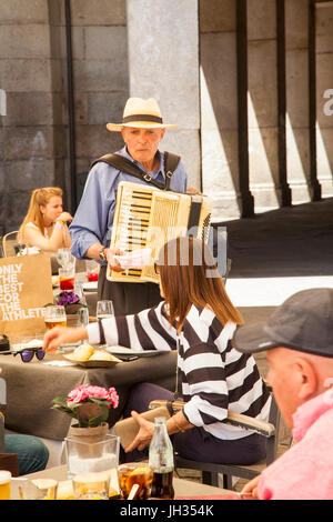 Uomo in un cappello di paglia suonare la fisarmonica a piano per persone cene presso un ristorante sulla piazza Mayor / Plaza Mayor Madrid Foto Stock