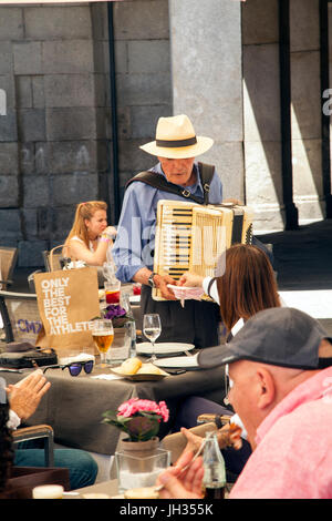 Uomo in un cappello di paglia suonare la fisarmonica a piano per persone cene presso un ristorante sulla piazza Mayor / Plaza Mayor Madrid Foto Stock