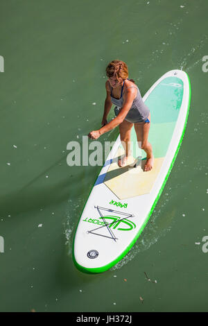 Donna stand up paddle imbarco su un fiume presa da sopra Foto Stock