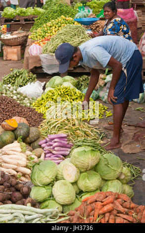 L'uomo vendita di verdura fresca presso il principale mercato ortofrutticolo in Colombo, Sri Lanka. Foto Stock