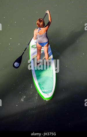 Donna stand up paddle imbarco su un fiume presa da sopra Foto Stock