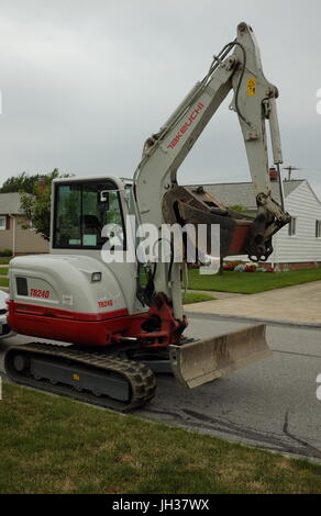 Un Takeuchi TB240 macchina è parcheggiata su una strada residenziale dove essa si adopererà attivamente partecipi di scavo. Foto Stock