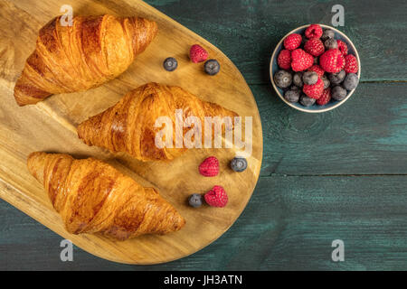 Croccanti croissant francesi con lamponi freschi e mirtilli Foto Stock