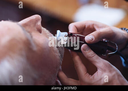 Rasoio elettrico essendo utilizzato per la regolazione della barba Foto Stock