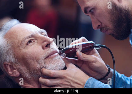 Felice Nizza uomo avente la sua barba tagliati Foto Stock