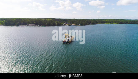 Vista aerea a seguito di un cavo galleggiante di traghetto tra korppo e Nagu parnas ferry terminal, su una soleggiata giornata estiva, nell'arcipelago finlandese di Turku Foto Stock