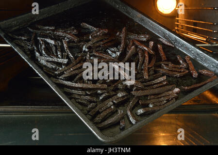 Bruciò cotto al forno patatine fritte Foto Stock