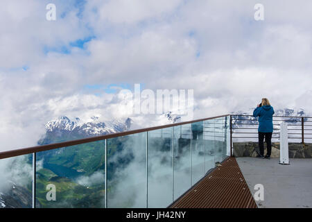 Tourist fotografare la vista panoramica dalla piattaforma di visualizzazione Dalsnibba sulla montagna che si affaccia Geirangerfjorden. Geiranger Sunnmøre Møre og Romsdal Norvegia Foto Stock