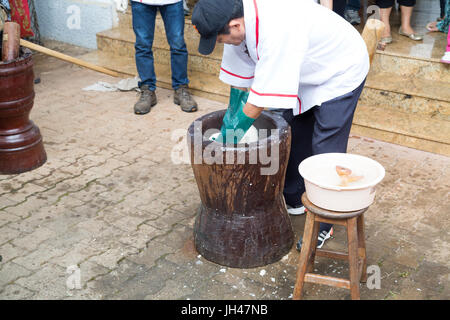 Giapponese fresca mochi essendo pestate utilizzando legno tradizionale e di usu vacche (grande mortaio e pestello), mochi riso torta fatta in occasione di una cerimonia chiamato mochitsu Foto Stock