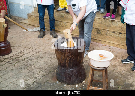 Giapponese fresca mochi essendo pestate utilizzando legno tradizionale e di usu vacche (grande mortaio e pestello), mochi riso torta fatta in occasione di una cerimonia chiamato mochitsu Foto Stock