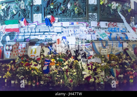 Marianne con la sua bandiera francese, fiori, candele di Place de la Republique. Omaggio alle vittime degli attentati terroristici a Parigi il 13 novembre. Foto Stock