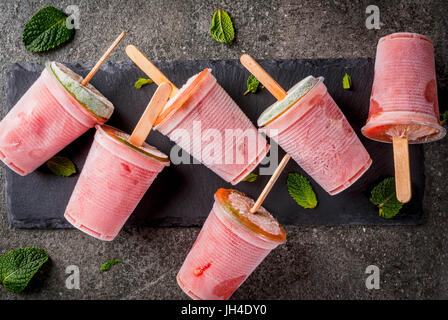 Gelato fatto in casa popsicles. Bevande Surgelati. Cocktail gelato di anguria o berry, menta e calce. Congelati cocktail Margarita con calce. Su nero sto Foto Stock