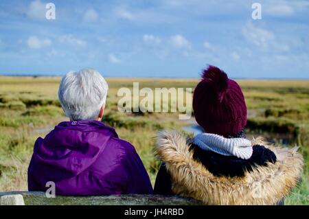 Due donne godendo la vista da una panca in campagna Foto Stock