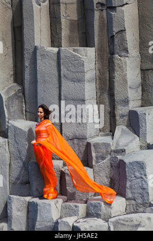 Donna indiana in posa sulle colonne di basalto in spiaggia Reynisfjara in Islanda Foto Stock