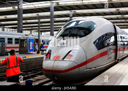 Deuthes Bundesbahn lavoratore la pulizia della parte anteriore di una alta velocità ICE (Inter City Express) treno motore in munich hauptbahnhof, Monaco di Baviera, Germania Foto Stock