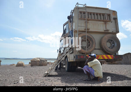 LOIYANGELENI, KENYA - Maggio 18. Un uomo si siede nell'ombra di un turista via da un El Molo villaggio a Loyangalani sulle rive del lago Turkana nel nord del Kenya occidentale. Credito: David Mbiyu/Alamy Live News Foto Stock