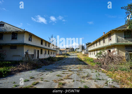 Incolto e Asfalto Screpolato street tra due deserte, condannato caserma Foto Stock