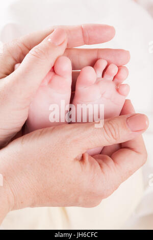 La mamma le mani tenere le dita dei piedi Foto Stock