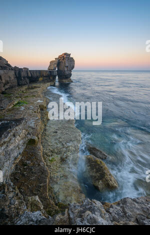 Twilight rompe su il celeberrimo pulpito Rock al Portland Bill su una chiara mattina di primavera lungo la Jurassic Coast in Dorset, England, Regno Unito Foto Stock