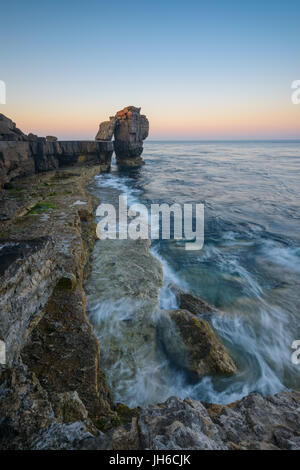 Twilight rompe su il celeberrimo pulpito Rock al Portland Bill su una chiara mattina di primavera lungo la Jurassic Coast in Dorset, England, Regno Unito Foto Stock