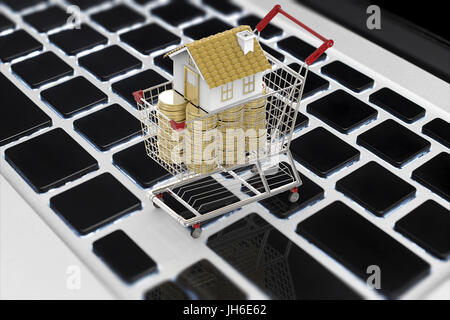 Business online di concetto con mock up house e la pila di monete nel carrello Foto Stock