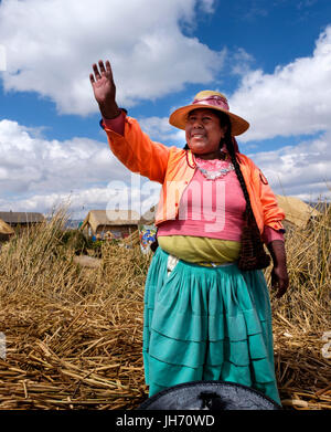 Isole Uros, Perù - circa ottobre 2015: Donna da Uros agitando mani e gente accogliente nelle isole galleggianti del lago Titicaca. Foto Stock