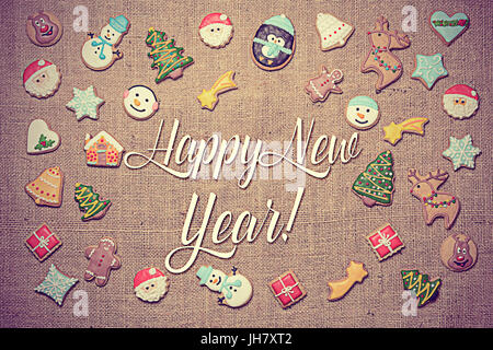 Felice Anno Nuovo! Messaggio di saluto festivo scritto tra decorativo biscotti di panpepato. Look Vintage aggiunti in fase di post-elaborazione. Foto Stock