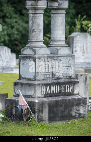 Vestito di stracci bandiera Confederate e veterano confederato maker accanto alla lapide memorial a Lawrenceville cimitero storico in Lawrenceville, Georgia, Stati Uniti d'America. Foto Stock