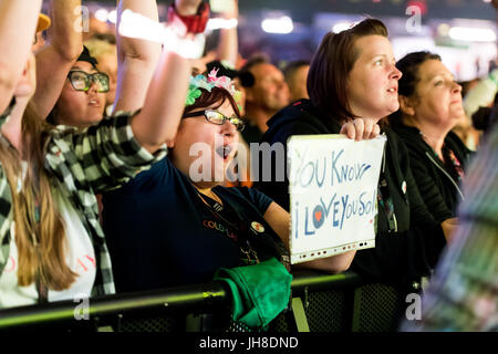 Ventilatori in mezzo alla folla guarda i Coldplay eseguire presso il Principato Stadium di Cardiff, il 11 luglio 2017. Foto Stock