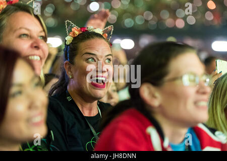 Ventilatori in mezzo alla folla guarda i Coldplay eseguire presso il Principato Stadium di Cardiff, il 11 luglio 2017. Foto Stock