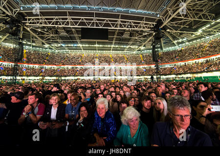 Ventilatori in mezzo alla folla guarda i Coldplay eseguire presso il Principato Stadium di Cardiff, il 11 luglio 2017. Foto Stock