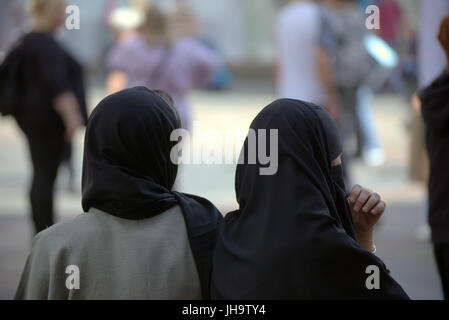 Famiglia asiatica rifugiato giovane donna una studentessa allievo vestito Hijab sciarpa su strada nel Regno Unito scena quotidiana camminando sulla strada Foto Stock