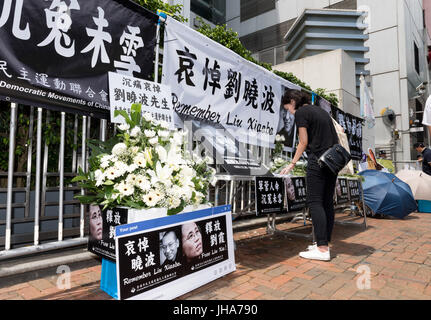 Hong Kong, Hong Kong, Cina. 14 Luglio, 2017. Ciò che era stato il sito di un sit-in di protesta per liberare Liu oggi è diventata il luogo del ricordo.Dopo la morte in Cina di Liu Xiaobo il Premio Nobel per la pace, la protesta fuori dall'Ufficio di collegamento del governo centrale del popolo nella regione amministrativa speciale di Hong Kong rimane in posizione con i libri di cordoglio disponibile a firmare. Credito: Jayne Russell/ZUMA filo/Alamy Live News Foto Stock