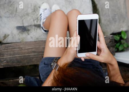 Donna che utilizza smartphone sopra vista dall'alto. Foto Stock