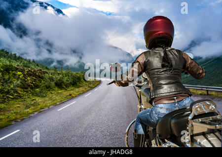 Biker ragazza scorre una strada di montagna in Norvegia. Visuale in prima persona. Foto Stock