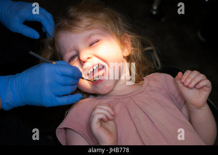 Il Toddler girl / 2 o 3 anni / due o tre anni di bambino durante il check up con il dentista per bambini / bambini pratica dentale. Regno Unito Foto Stock