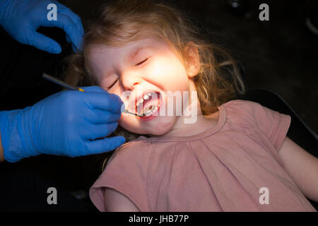 Il Toddler girl / 2 o 3 anni / due o tre anni di bambino durante il check up con il dentista per bambini / bambini pratica dentale. Regno Unito Foto Stock