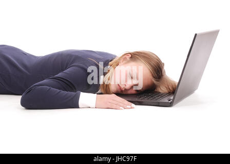 Immagine della cute giovane ragazza dorme si trova nei pressi di computer portatile isolato su uno sfondo bianco. Foto Stock