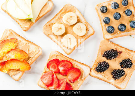 Tradizionale americana ed europea e in estate la colazione: sandwich di pane tostato con burro di arachidi, Berry, frutta mela, pesca, mirtillo, mirtillo, strawberr Foto Stock