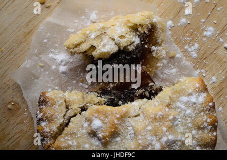 Tettuccio di close up di tritare la torta, rotte aperte come se parzialmente consumato, con ripieno di frutta esposta e la pasticceria briciole sparse. Foto Stock