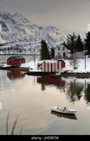 Barca da pesca ormeggiate a terra in Austnesfjorden Vestpollen vicino villaggio. Case in Vestpolloya isola-Nordlia e supporti Slettlia sfondo. Centra Foto Stock