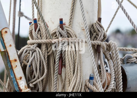 Vela funi legate fino al montante su una nave a vela Foto Stock