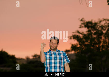 Uomo al tramonto con il pugno chiuso. Foto Stock