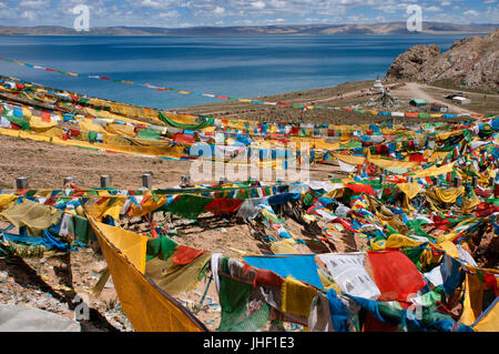 Bandiere di preghiera all'ingresso del lago sacro di Nam Tso (4700 m, uno dei laghi più grandi del mondo) situato nella punta settentrionale del Tibet. Foto Stock